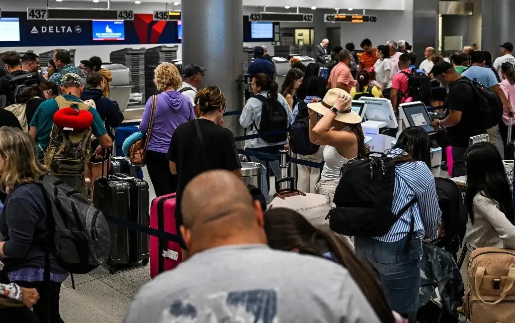 Los pasajeros del Aeropuerto Internacional de Miami hacen fila en los mostradores de facturación durante una importante interrupción de los sistemas informáticos a nivel mundial, el 19 de julio de 2024. 