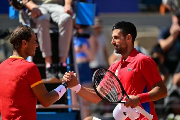 El ganador, el serbio Novak Djokovic (der.) estrecha la mano al español Rafael Nadal (izq.) después de su partido de tenis de segunda ronda individual masculino en la cancha Philippe-Chatrier en el Estadio Roland-Garros en los Juegos Olímpicos de París 2024, en París el 29 de julio de 2024.