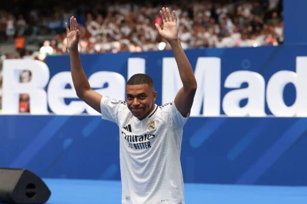 El delantero francés Kylian Mbappé saluda a los aficionados durante su primera aparición como jugador del Real Madrid en el Estadio Santiago Bernabéu de Madrid, el 16 de julio de 2024.