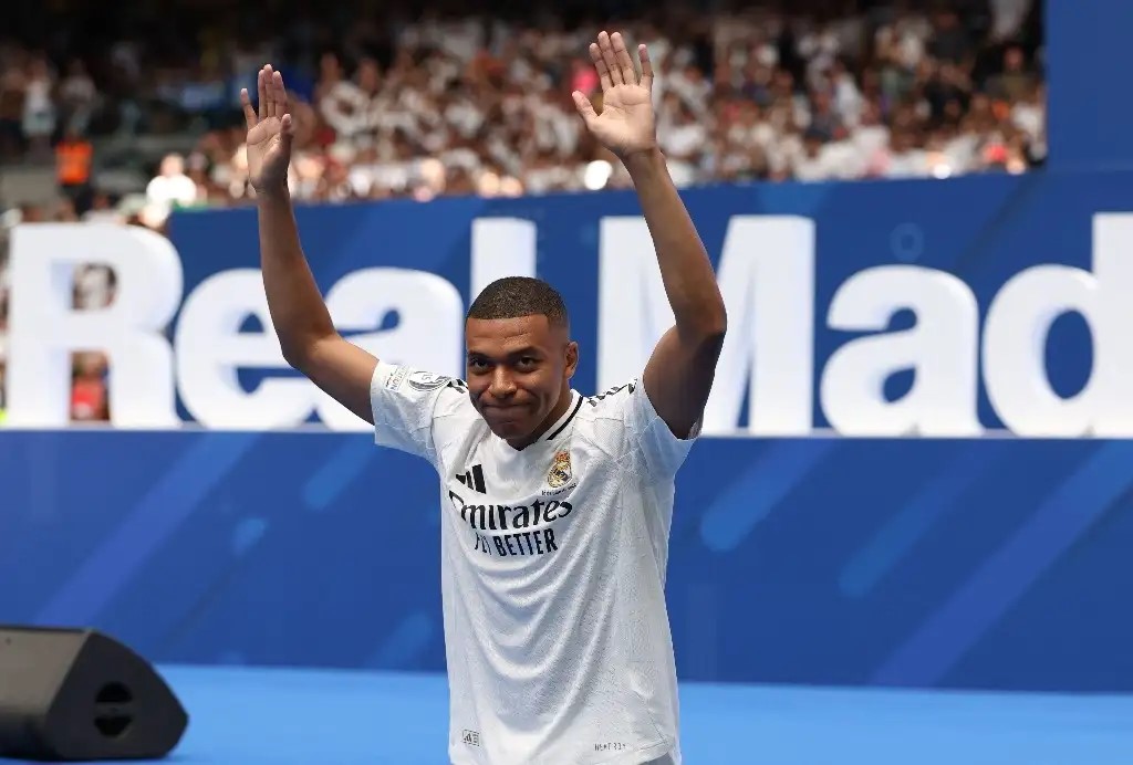 El delantero francés Kylian Mbappé saluda a los aficionados durante su primera aparición como jugador del Real Madrid en el Estadio Santiago Bernabéu de Madrid, el 16 de julio de 2024.