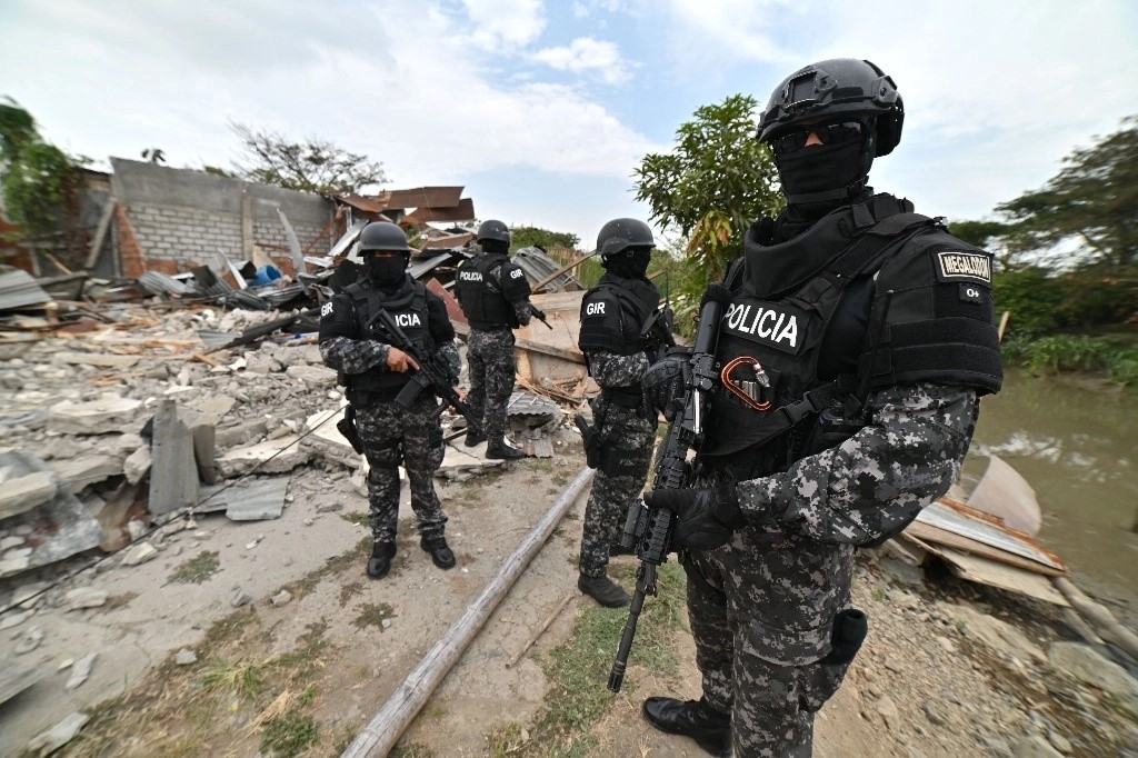 Fuerzas de seguridad vigilan durante un operativo para destruir viviendas que, según las autoridades, eran utilizadas por la banda criminal Chone Killer para tomar rehenes y asesinar a sus víctimas en Durán, Ecuador, el 3 de octubre de 2024.