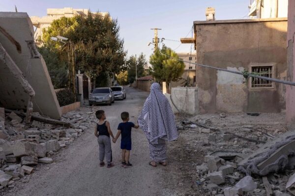 Una mujer y sus dos hijos caminan entre los escombros dejados por un ataque israelí en Baalbek, al este de Líbano.