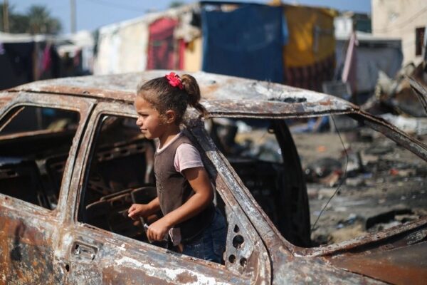 Una niña palestina encontró un sitio para jugar en los restos de un automóvil destruido por bombardeos de Israel en Deir el Balah.