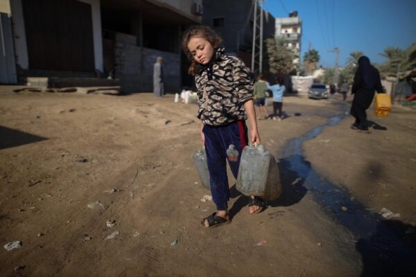 Ataques y desplazamientos forzosos ordenados por Israel en la franja han llevado a su población a situaciones inhumanas. En la imagen, una niña lleva agua a su refugio en Deir al Balh.