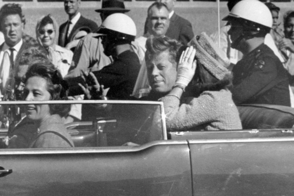 El presidente John F. Kennedy saluda desde su automóvil en una caravana por las calles de Dallas, al lado de su esposa, Jacqueline Kennedy, en imagen del 22 de noviembre de 1963. En el recorrido el mandatario fue asesinado.