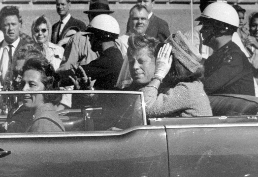 El presidente John F. Kennedy saluda desde su automóvil en una caravana por las calles de Dallas, al lado de su esposa, Jacqueline Kennedy, en imagen del 22 de noviembre de 1963. En el recorrido el mandatario fue asesinado.