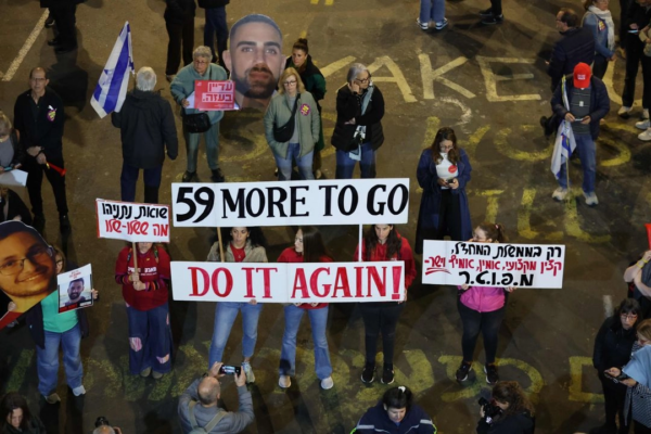 Los manifestantes levantan carteles durante una manifestación de familiares y parientes de israelíes tomados como rehenes por militantes palestinos en Gaza desde octubre de 2023, exigiendo acciones para su liberación, frente al Ministerio de Defensa israelí en Tel Aviv el 8 de marzo de 2025.