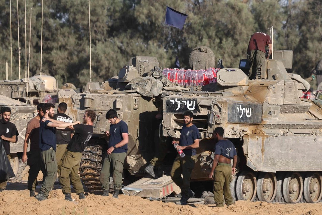 Soldados israelíes se reúnen junto a tanques en una posición cerca de la frontera de Israel con la Franja de Gaza, el 5 de mayo de 2025.