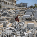 Un niño palestino observa las tumbas destruidas por fuerzas israelíes, que atacaron la mezquita de Ansar y el cementerio adyacente en Deir-el-Balah, en la zona central de la franja de Gaza.