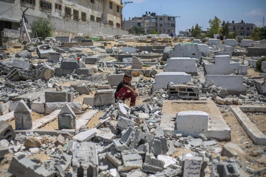 Un niño palestino observa las tumbas destruidas por fuerzas israelíes, que atacaron la mezquita de Ansar y el cementerio adyacente en Deir-el-Balah, en la zona central de la franja de Gaza.