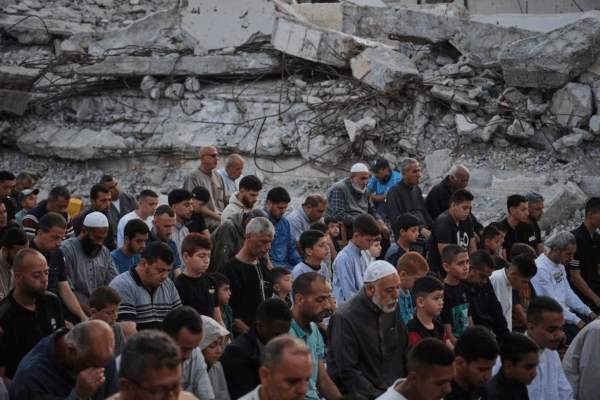 Palestinos rezan junto a las ruinas de una mezquita destruida hace pocos días por proyectiles del ejército israelí, en Deir al Balah.