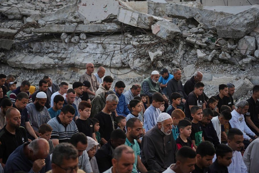Palestinos rezan junto a las ruinas de una mezquita destruida hace pocos días por proyectiles del ejército israelí, en Deir al Balah.
