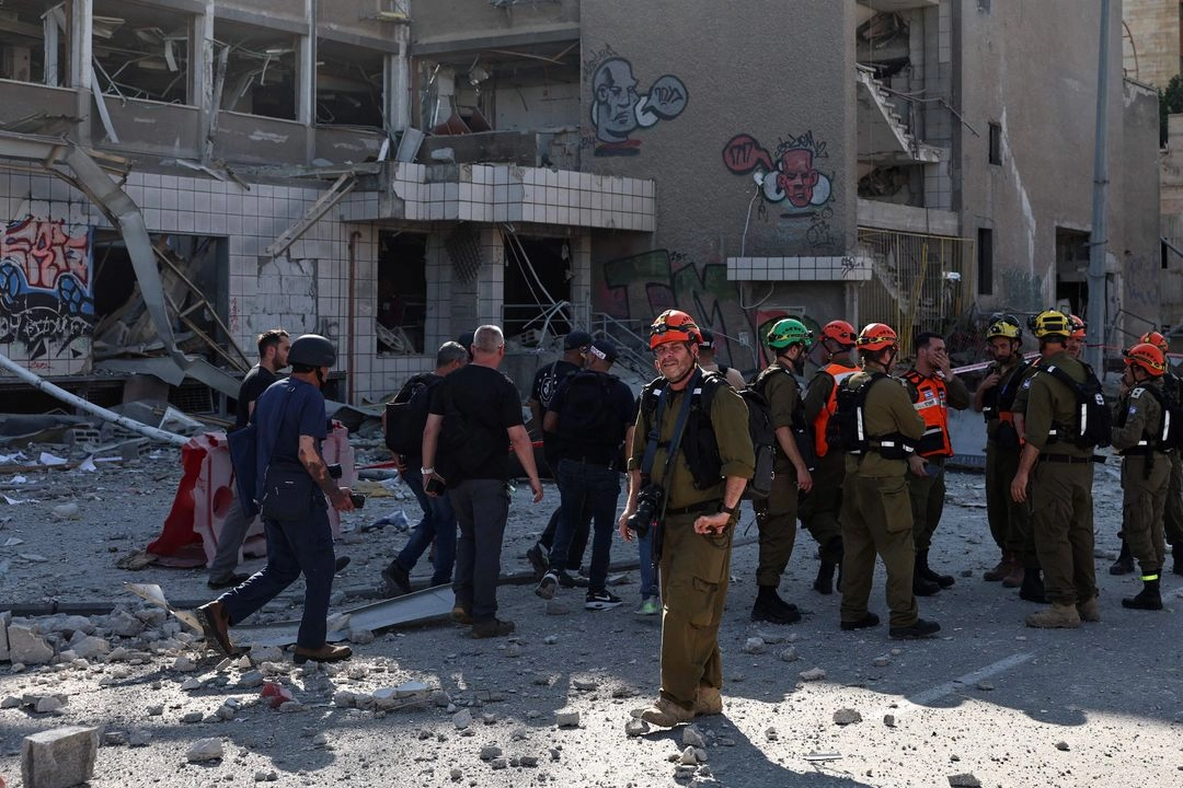 Los socorristas israelíes se reúnen frente a un edificio presuntamente alcanzado por un ataque iraní en Haifa, en medio del continuo intercambio de disparos entre Israel e Irán, el 20 de junio de 2025.