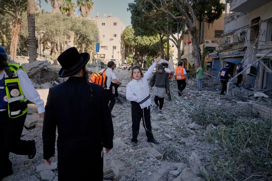 Civiles y rescatistas observan el sitio del impacto de un cohete iraní en un edificio de la ciudad israelí de Haifa.