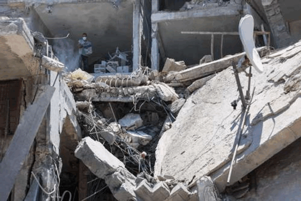 Un palestino intenta recuperar algunos bienes de su vivienda, en un edificio destruido un día antes por ataques israelíes en el barrio de Al-Daraj, en Gaza.