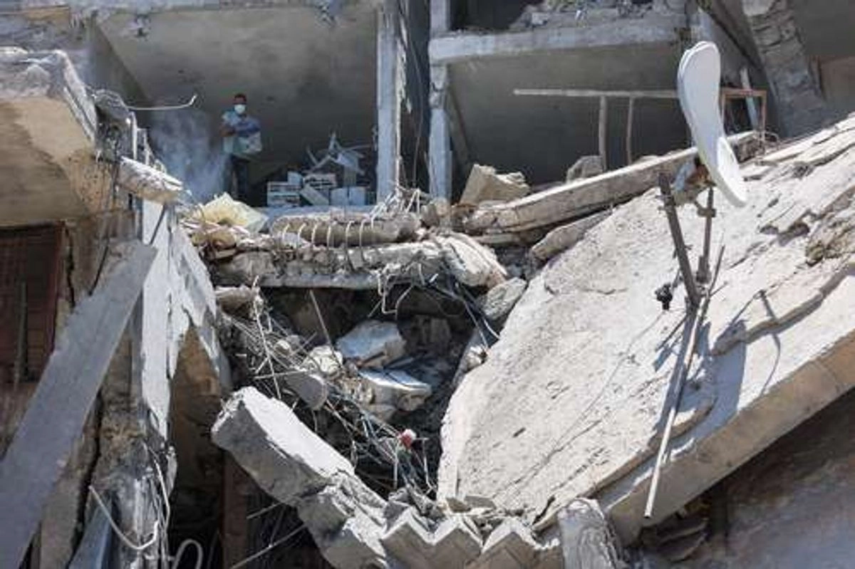 Un palestino intenta recuperar algunos bienes de su vivienda, en un edificio destruido un día antes por ataques israelíes en el barrio de Al-Daraj, en Gaza.