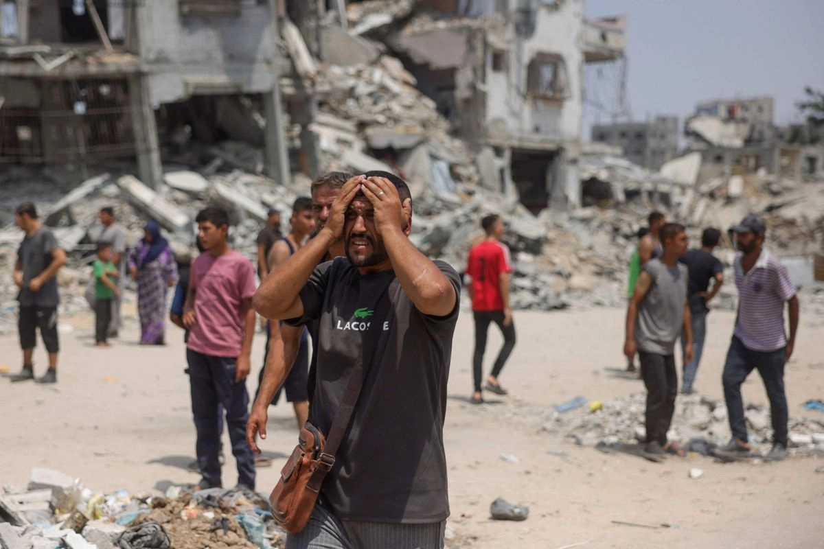 Un hombre reacciona mientras los médicos transportan a víctimas de los ataques israelíes contra los miembros de los comités de seguridad establecidos para prevenir el robo de ayuda, al oeste de Jabalia, Gaza, el 13 de agosto de 2025.