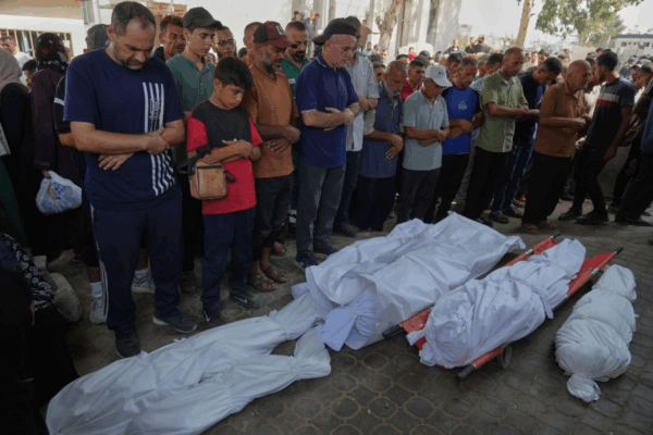 Un grupo de personas reza en torno a los cuerpos de seis palestinos que, de acuerdo con sus familias, murieron en un ataque aéreo de las Fuerzas de Defensa de Israel.