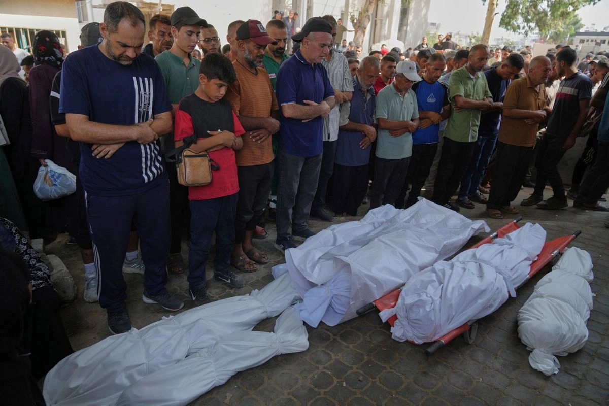 Un grupo de personas reza en torno a los cuerpos de seis palestinos que, de acuerdo con sus familias, murieron en un ataque aéreo de las Fuerzas de Defensa de Israel.