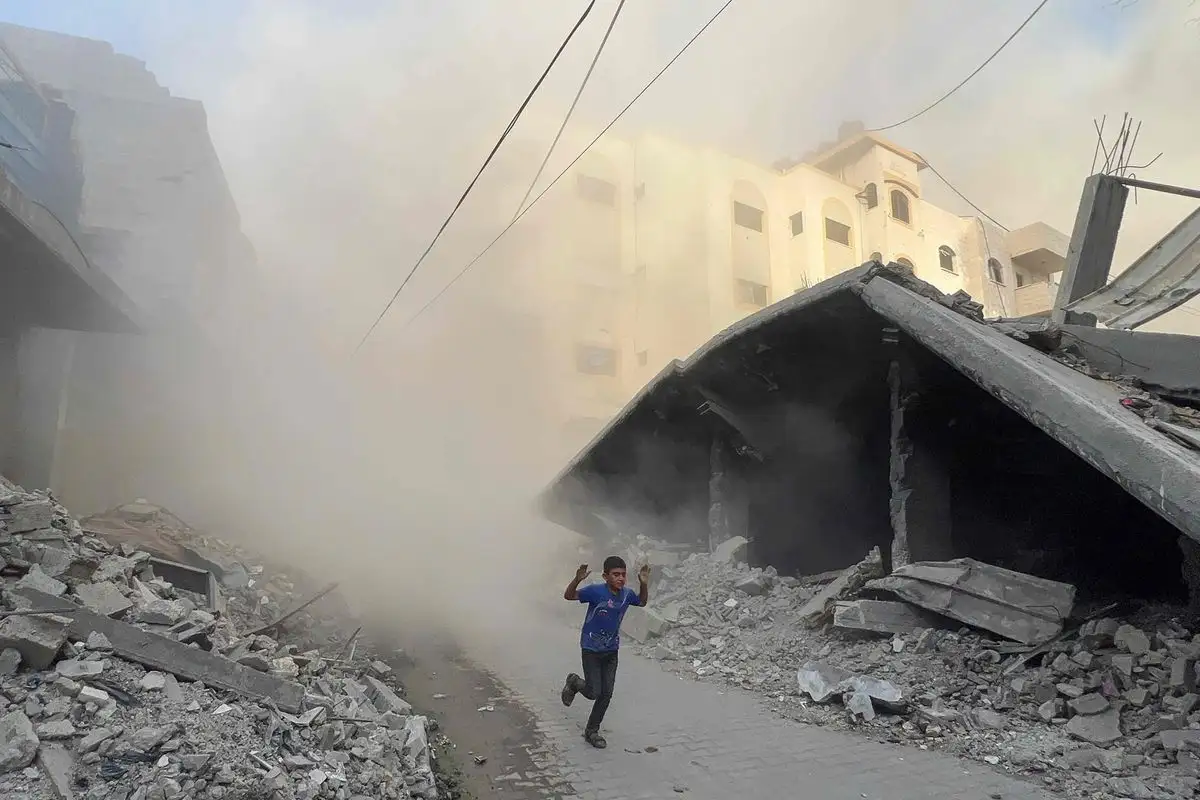 Un niño palestino huye de bombardeos contra un edificio de seis pisos en Jabaliya, en el norte de Gaza. Ayer, 60 personas fueron asesinadas en ataques israelíes en la franja.