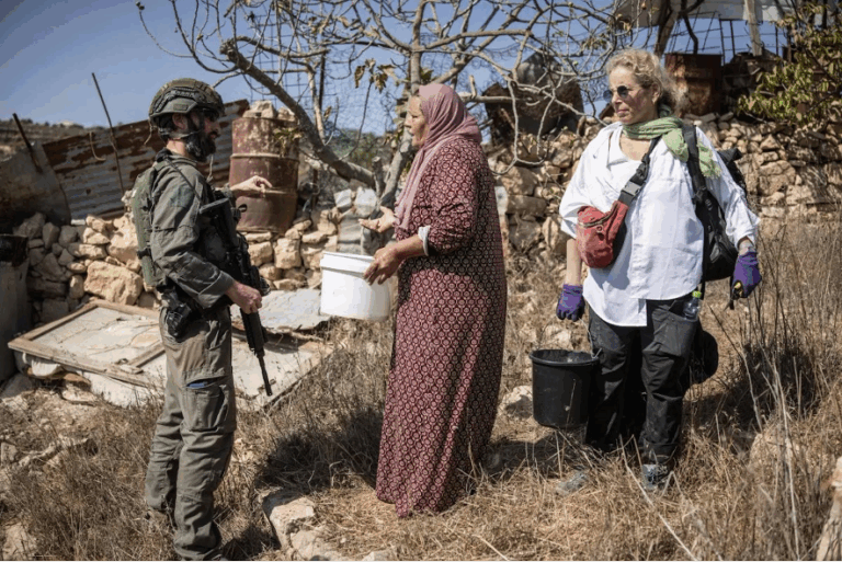 Un soldado israelí intenta detener la cosecha en un olivar palestino cerca del asentamiento israelí de Elazar, al sur de Belén, en la Cisjordania reocupada.