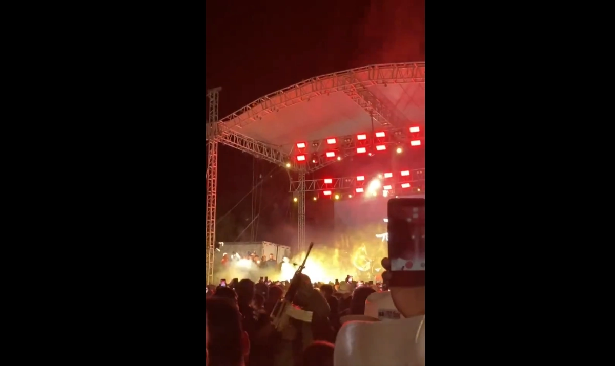 Usuarios de redes sociales captaron el momento en el que un sujeto usa un arma larga y dispara al aire en pleno concierto.