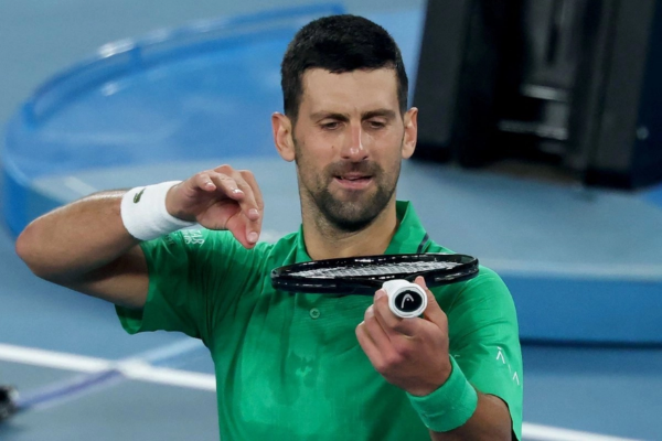 El serbio Novak Djokovic simula tocar el violín con la raqueta mientras celebra su victoria en el Abierto de Australia.