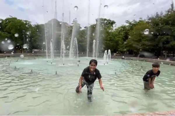 Niños juegan en una fuente pública de Hermosillo para resistir el calor.