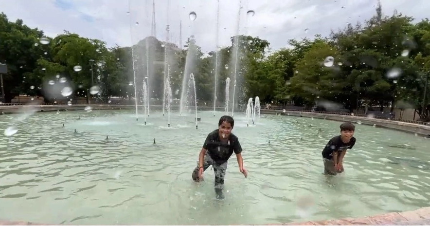 Niños juegan en una fuente pública de Hermosillo para resistir el calor.