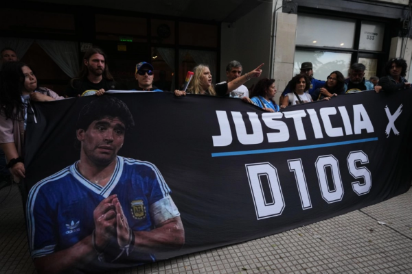 Aficionados del fallecido astro del futbol Diego Armando Maradona se congregan a las afueras del tribunal en el primer día del juicio contra su equipo médico por presunto homicidio por negligencia en San Isidro, Argentina.
