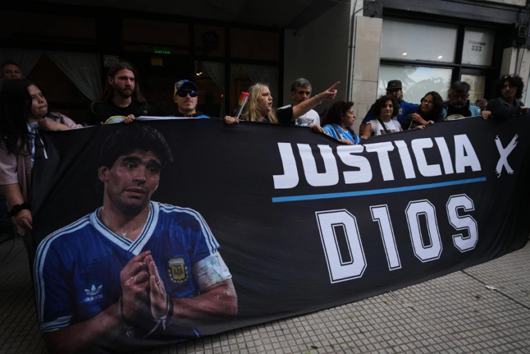 Aficionados del fallecido astro del futbol Diego Armando Maradona se congregan a las afueras del tribunal en el primer día del juicio contra su equipo médico por presunto homicidio por negligencia en San Isidro, Argentina.