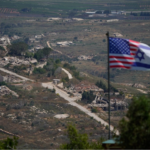 Banderas israelíes y estadounidenses ondean sobre un fondo de edificios destruidos en el sur del Líbano, tal como se ve desde el norte de Israel, el domingo 21 de junio de 2026.