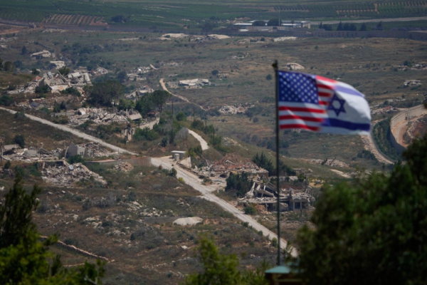 Banderas israelíes y estadounidenses ondean sobre un fondo de edificios destruidos en el sur del Líbano, tal como se ve desde el norte de Israel, el domingo 21 de junio de 2026.