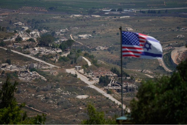 Banderas israelíes y estadounidenses ondean sobre un fondo de edificios destruidos en el sur del Líbano, tal como se ve desde el norte de Israel, el domingo 21 de junio de 2026.