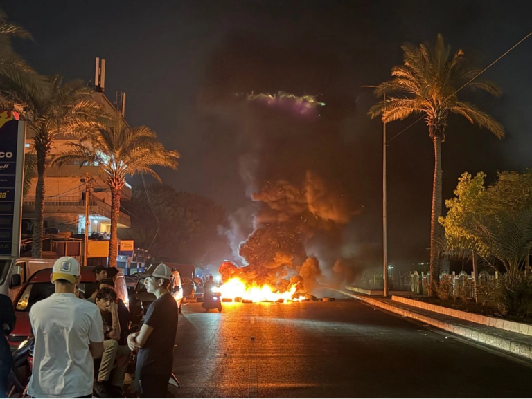 Partidarios de Hezbollah bloquean la antigua carretera del aeropuerto, en los suburbios del sur de Beirut, quemando neumáticos para protestar contra el acuerdo tripartito firmado entre Estados Unidos, Israel y el Líbano.
