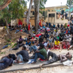 Migrantes descansan afuera del Centro Temporal de Inmigrantes (CETI) tras cruzar de Marruecos al enclave español de Ceuta