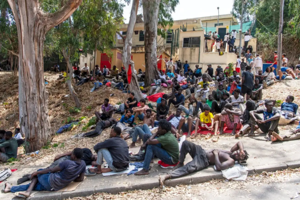 Migrantes descansan afuera del Centro Temporal de Inmigrantes (CETI) tras cruzar de Marruecos al enclave español de Ceuta