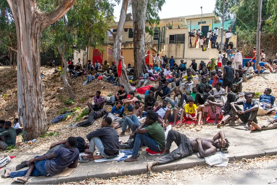 Migrantes descansan afuera del Centro Temporal de Inmigrantes (CETI) tras cruzar de Marruecos al enclave español de Ceuta