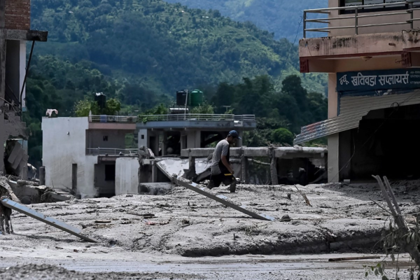 Un hombre recupera pertenencias de su casa, anegada por el lodo tras unas inundaciones repentinas en la zona de Devighat, en el distrito nepalí de Nuwakot, el 27 de agosto de 2026.