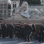 Agentes de los Carabineros conversan con personas en la plaza del Duomo, en Milán (Italia), un día después de que manifestantes violentos se enfrentaran a la policía, saquearan tiendas y prendieran fuego a propiedades.