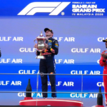 El piloto de Red Bull Max Verstappen, de los Países Bajos, celebra en el podio flanqueado por el piloto de Mercedes Andrea Kimi Antonelli, de Italia —segundo clasificado, a la izquierda—, y el piloto de Ferrari Lewis Hamilton, de Gran Bretaña —tercer clasificado—, tras ganar el Gran Premio de Baréin en Sepang, Malasia, el domingo 4 de octubre de 2026.