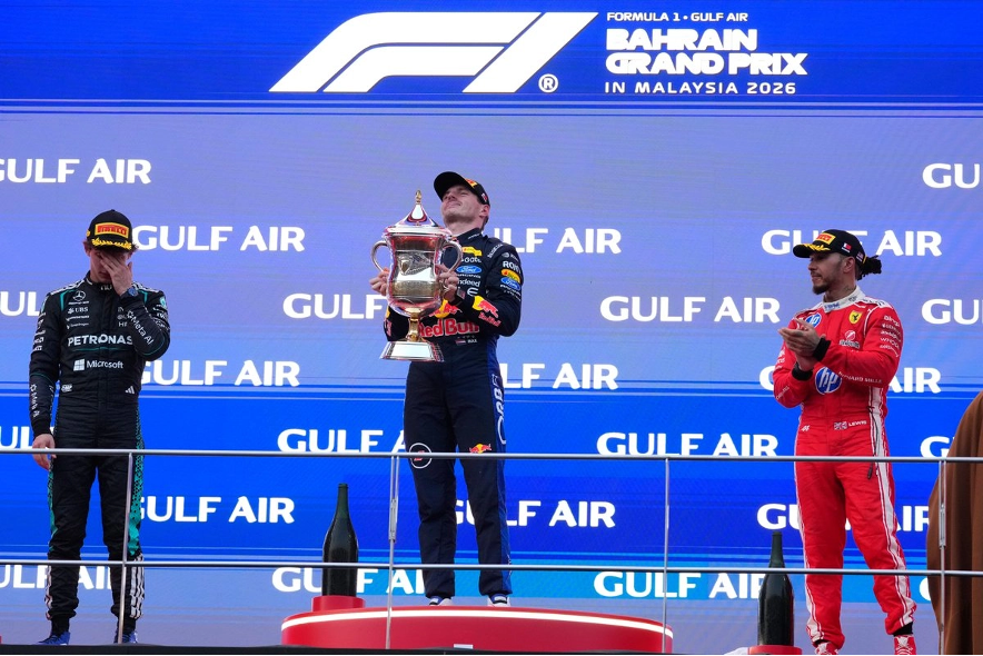 El piloto de Red Bull Max Verstappen, de los Países Bajos, celebra en el podio flanqueado por el piloto de Mercedes Andrea Kimi Antonelli, de Italia —segundo clasificado, a la izquierda—, y el piloto de Ferrari Lewis Hamilton, de Gran Bretaña —tercer clasificado—, tras ganar el Gran Premio de Baréin en Sepang, Malasia, el domingo 4 de octubre de 2026.